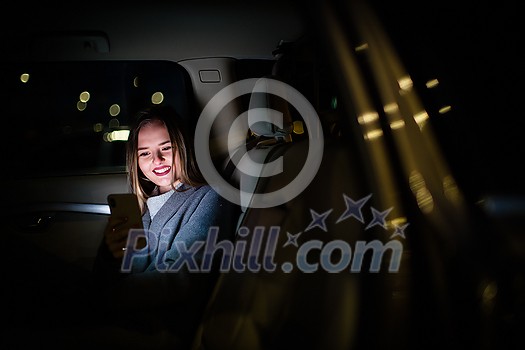 Young woman with her cell phone sitting in the backseat of a car, getting ready to travel (color toned image; shallow DOF) Young woman with her cell phone sitting in the backseat of a car, getting ready to travel (color toned image; shallow DOF)