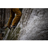 A rock climber climbing on a boulder rock outdoors. Group of friends involved in sports outside.