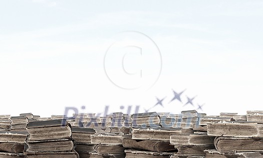 Hand with book reaching out from pile of old books Hand with book reaching out from pile of old books