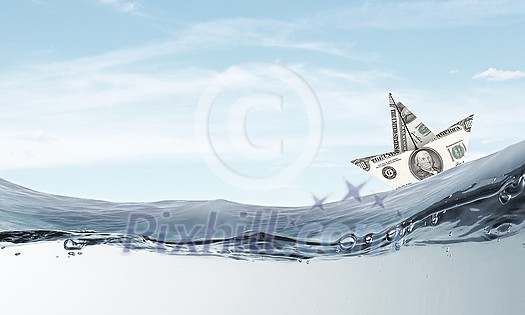 Ship made of dollar banknote floating in water Ship made of dollar banknote floating in water