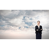 Young businesswoman with closed eyes thinking something over