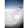 Aircraft porthole with blue sky. Looking through window aircraft during flight. Airplane wing through the porthole. Looking through window aircraft during flight