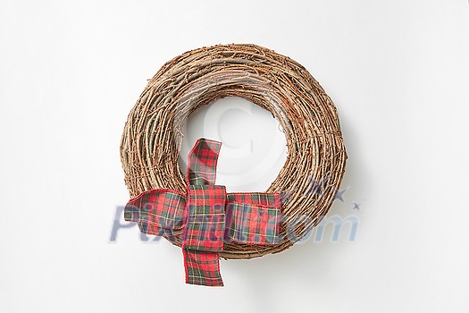 Decorative handmade festive wreath from twigs with textile bow ribbon against white background, copy space. Greeting card. Decorative handmade festive wreath from twigs with textile bow ribbon against white background, copy space. Greeting card.