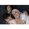 group of arab teens taking selfie photo on smart phone with black chalkboard in background