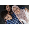 group of arab teens taking selfie photo on smart phone with black chalkboard in background