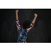 happy arab teenager celebrating wearing  backpack  casual school look against black chalkboard background