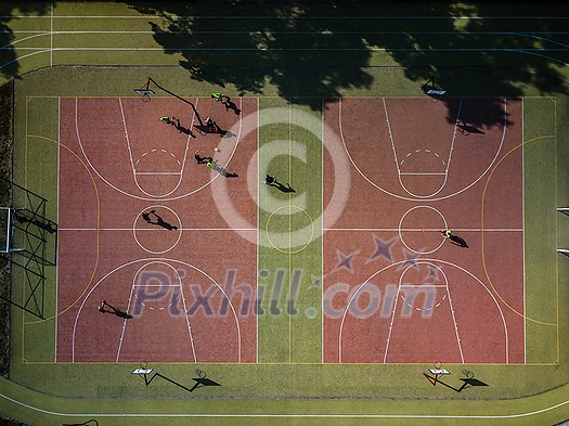Aerial view of a soccer pitch with people playing soccer on it - in warm morning sun, casting long shadows Aerial view of a soccer pitch with people playing soccer on it - in warm morning sun, casting long shadows