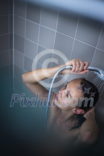Pretty, young woman taking a long hot shower washing her hair in a modern design bathroom Pretty, young woman taking a long hot shower washing her hair in a modern design bathroom