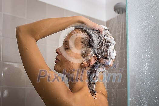 Pretty, young woman taking a long hot shower washing her hair in a modern design bathroom Pretty, young woman taking a long hot shower washing her hair in a modern design bathroom