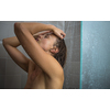 Pretty, young woman taking a long hot shower washing her hair in a modern design bathroom