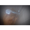 Pretty, young woman taking a long hot shower washing her hair in a modern design bathroom
