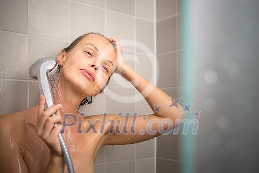 Pretty, young woman taking a long hot shower washing her hair in a modern design bathroom Pretty, young woman taking a long hot shower washing her hair in a modern design bathroom
