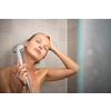 Pretty, young woman taking a long hot shower washing her hair in a modern design bathroom
