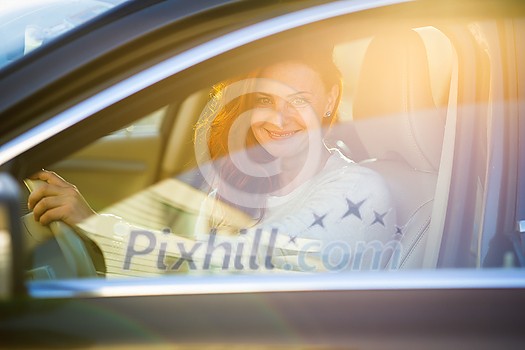 Pretty, young woman driving a car -Invitation to travel. Car rental or vacation. Pretty, young woman driving a car -Invitation to travel. Car rental or vacation.