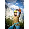 Pretty, female climber on a via ferrata - climbing on a rock in Swiss Alps
