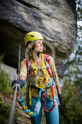 Pretty, female climber on a via ferrata - climbing on a rock in Swiss Alps Pretty, female climber on a via ferrata - climbing on a rock in Swiss Alps