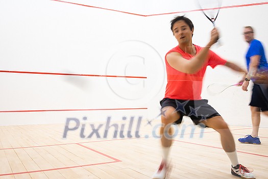 Squash players in action on a squash court (motion blurred image; color toned image) Squash players in action on a squash court (motion blurred image; color toned image)