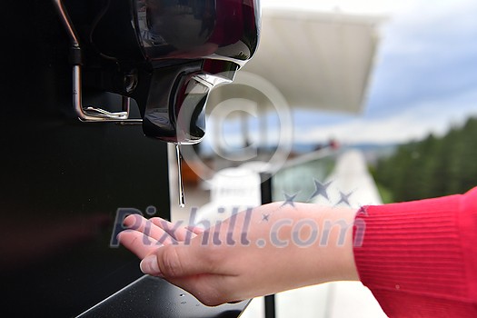 Guests in restaurant Washing hands using automatic gel disinfection sanitizer. Coronavirus prevention in a caffee restaurant during the corona virus epidemic and new normal outbreak concept Guests in restaurant Washing hands using automatic gel disinfection sanitizer. Coronavirus prevention in a caffee restaurant during the corona virus epidemic and new normal outbreak concept