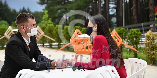 couple with protective medical mask having coffee break in a restaurant, new normal coronavirus concept couple with protective medical mask having coffee break in a restaurant, new normal coronavirus concept
