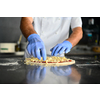 Skilled chef preparing traditional italian pizza  in interior of modern restaurant kitchen with special wood-fired oven. Wearing protective medical face mask and gloves in coronavirus new normal concept