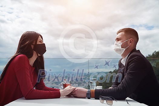 couple with protective medical mask having coffee break in a restaurant, new normal coronavirus concept couple with protective medical mask having coffee break in a restaurant, new normal coronavirus concept