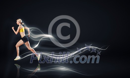 Young woman athlete running fast on dark background Young woman athlete running fast on dark background