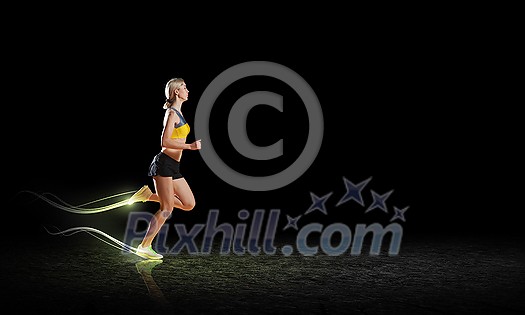 Young woman athlete running fast on dark background Young woman athlete running fast on dark background