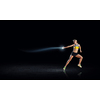 Young woman athlete running fast on dark background 