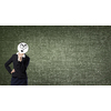 Businesswoman hiding her face behind paper mask
