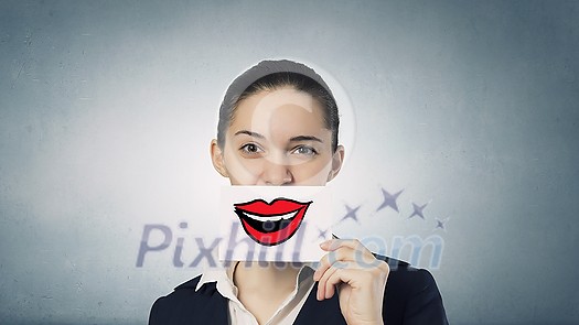 Pretty young girl holding white card with drawn smile Pretty young girl holding white card with drawn smile