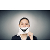 Pretty young girl holding white card with drawn smile with teeth