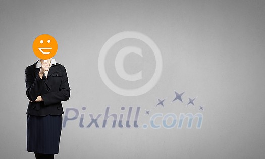 Unrecognizable businesswoman hiding her sadness behind smiley mask Unrecognizable businesswoman hiding her sadness behind smiley mask