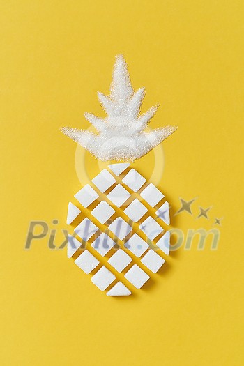 Exotic fruits composition creative pineapple handmade from rafined anf granulated sweet sugar on a yellow background with copy space. Flat lay. Exotic fruits composition creative pineapple handmade from rafined anf granulated sweet sugar on a yellow background with copy space. Flat lay.