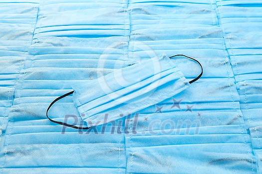 Antibacterial medical protective blue face mask on the same color background from masks. Concept of prevention from respiratory sickness and viruses. Antibacterial medical protective blue face mask on the same color background from masks. Concept of prevention from respiratory sickness and viruses.