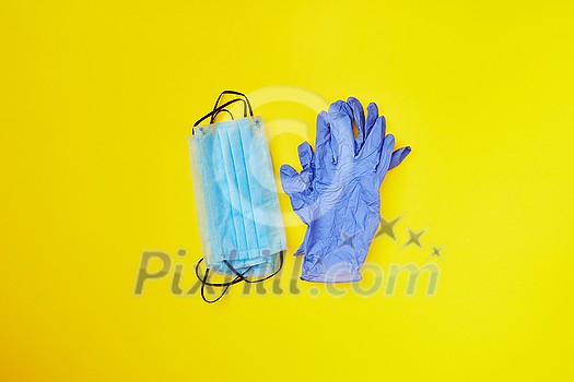 Things for prevention from respiratory sickness and viruses - two piles from medical protective masks and rubber gloves on a yellow background, copy space. Top view. Things for prevention from respiratory sickness and viruses - two piles from medical protective masks and rubber gloves on a yellow background, copy space. Top view.