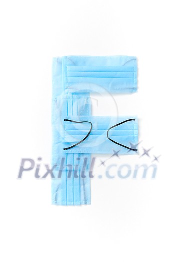 Capital letter F handmade from medical antibacterial protective blue face masks on a white background, copy space. Creative alphabet for making up new words.