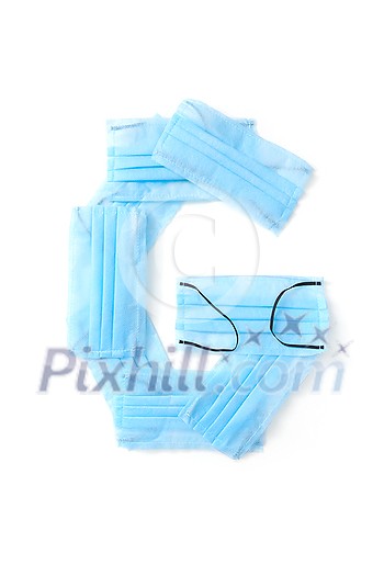 Capital letter G handmade from medical antibacterial protective blue face masks on a white background, copy space. Creative alphabet for making up new words. Capital letter G handmade from medical antibacterial protective blue face masks on a white background, copy space. Creative alphabet for making up new words.