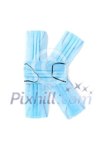 Capital letter K handmade from medical antibacterial protective blue face masks on a white background, copy space. Creative alphabet for making up new words. Capital letter K handmade from medical antibacterial protective blue face masks on a white background, copy space. Creative alphabet for making up new words.