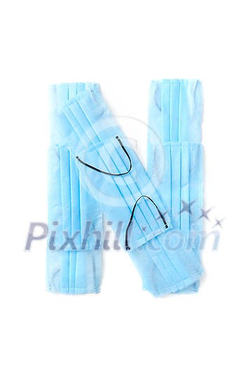 Capital letter N handmade from medical antibacterial protective blue face masks on a white background, copy space. Creative alphabet for making up new words. Capital letter N handmade from medical antibacterial protective blue face masks on a white background, copy space. Creative alphabet for making up new words.