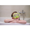 little girl with snorkel goggles in the tub while taking a bath in the bathtub, kids hygiene concept and summer vacation in corona virus stay at home