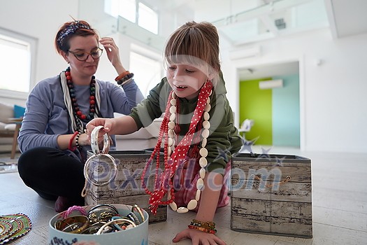 Mother and little girl daughter playing with jewelry while staying at home in coronavirus quarantine Mother and little girl daughter playing with jewelry while staying at home in coronavirus quarantine