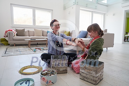 Mother and little girl daughter playing with jewelry while staying at home in coronavirus quarantine Mother and little girl daughter playing with jewelry while staying at home in coronavirus quarantine