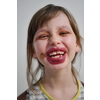 Cute little preschool girl playing with mommy's make up. Fashion experiment little child applying makeup lipstick and shadow on face, staying at home in corona virus quarantine.