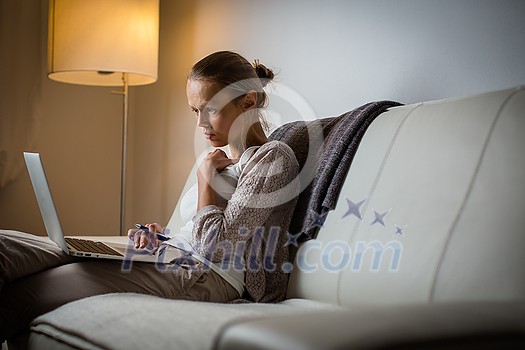 Very tired young woman, burning the midnigh oil - working late at night on her laptop computer, at home, sitting on sofa, rubbing her tired eyes, trying to stay focused Very tired young woman, burning the midnigh oil - working late at night on her laptop computer, at home, sitting on sofa, rubbing her tired eyes, trying to stay focused