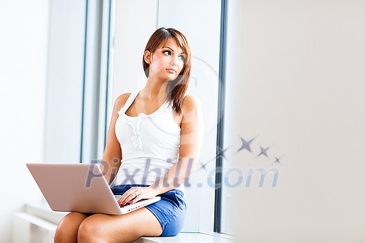Pretty, young woman working on a laptop computer Pretty, young woman working on a laptop computer