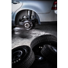 Modern car in a garage having its wheels/tires changed (shallow DOF; color toned image)