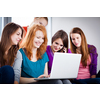 Group of female college students working on their homework/having a chat in between the lectures, using a laptop computer (color toned image)