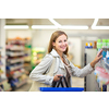 Beautiful young woman shopping in a grocery store/supermarket (color toned image). Waiting in the queue