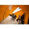 People rushing through a subway corridor (motion blur technique is used to convey movement)