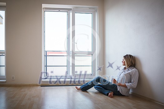 Just moved in: pretty, young woman having a drink in her brand new modern apartment Just moved in: pretty, young woman having a drink in her brand new modern apartment